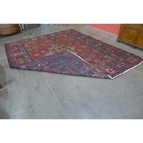 146 - An Iranian red ground rug, 395 x 325cms