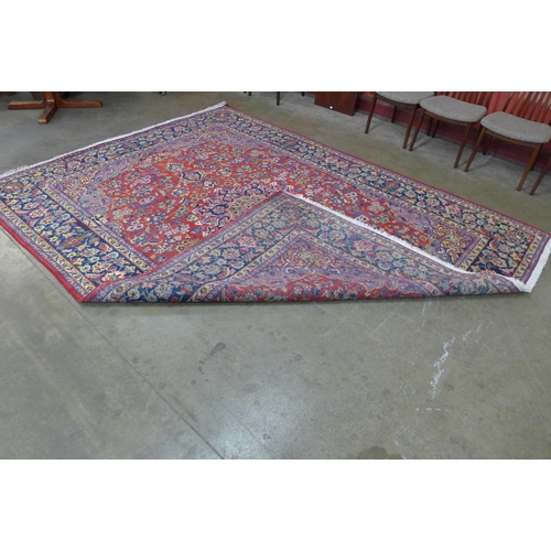 147 - An Iranian red ground rug, 332 x 253cms