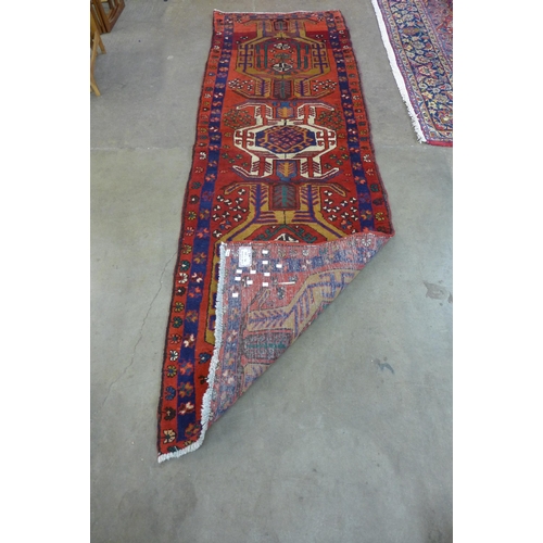 148 - An Iranian red ground runner rug, 306 x 99cms