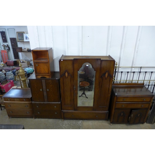 166 - An Art Deco oak three piece bedroom suite, comprising; wardrobe, chest of drawers and a tallboy