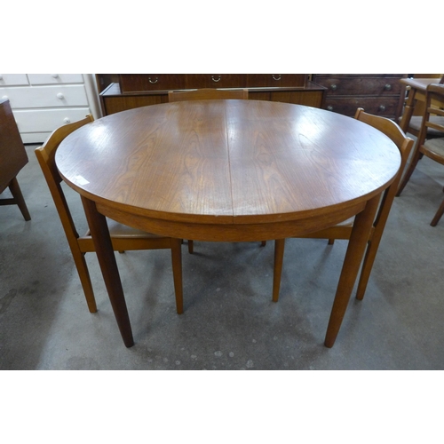 20 - A teak circular extending dining table and four chairs