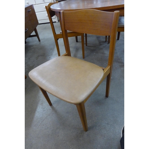 20 - A teak circular extending dining table and four chairs