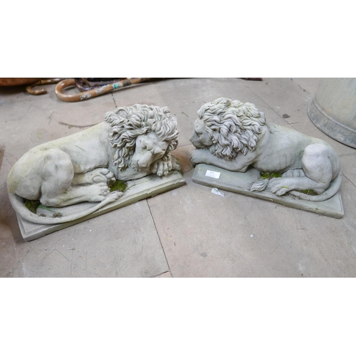 213 - A pair of concrete garden figures of recumbent lions