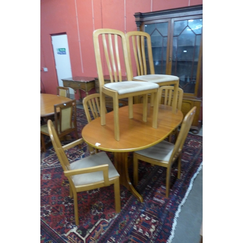 27 - A teak oval extending dining table and six chairs