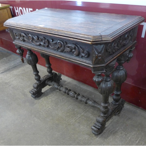 61 - A 19th Century French carved oak fold-over games table