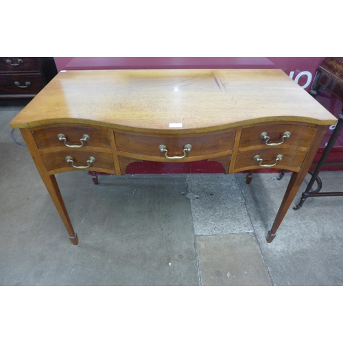 64 - An Edward VII mahogany five drawer serpentine writing table