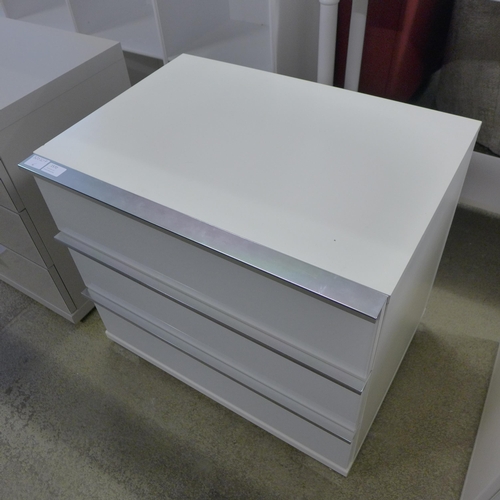 1570 - A white glass fronted three drawer bedside chest * this lot is subject to VAT