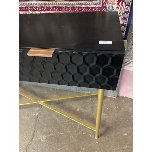 1389 - A black and gold console table with geometric patterned drawer