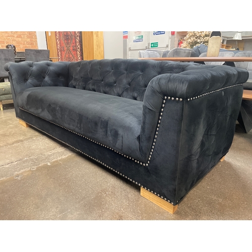 1472 - A black velvet upholstered buttoned three seater sofa