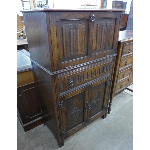 130 - A carved oak linenfold cocktail cabinet