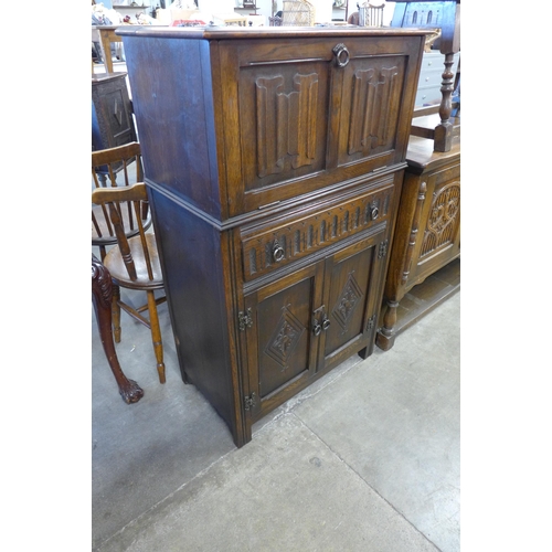 130 - A carved oak linenfold cocktail cabinet