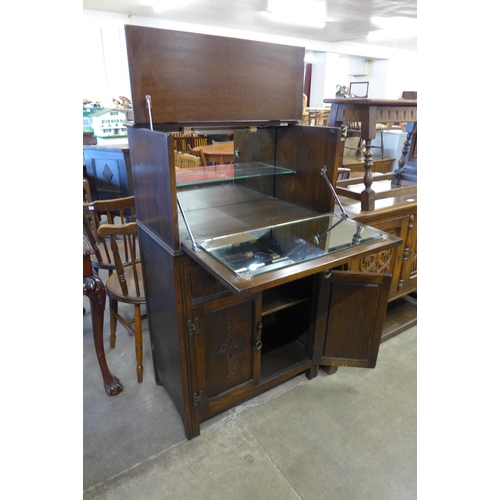 130 - A carved oak linenfold cocktail cabinet