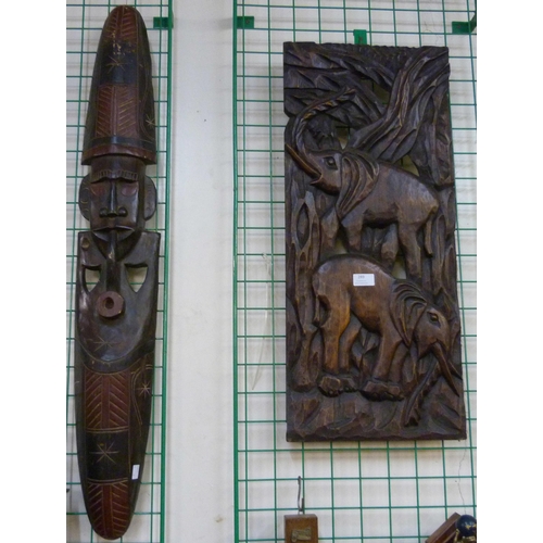 258 - An African carved wooden wall mask and a carved elephant plaque