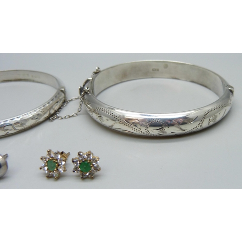 1009 - Two silver bangles, a pair of silver earrings and a pair of unmarked cluster earrings