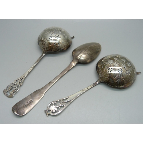 823 - Two silver tea strainers and an Irish silver spoon, 122g