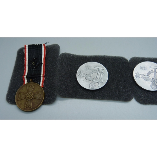 843 - A German WWII War Merit medal and three badges with pins