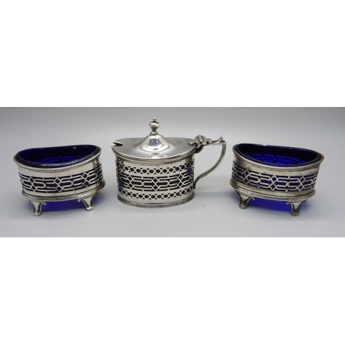 864 - A silver three piece cruet set with blue glass liners, Chester 1916; a pair of salts and mustard, 14... 