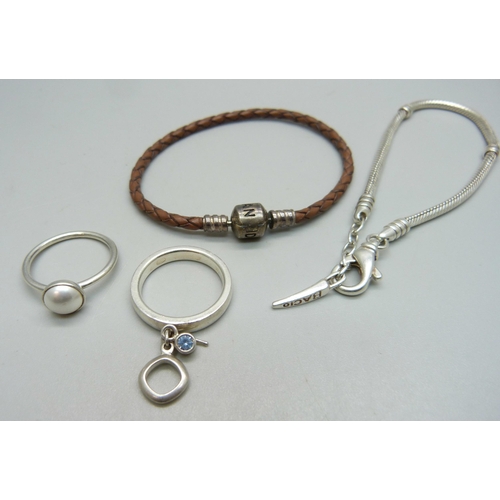 906 - A Pandora charm bracelet, a silver Pandora ring, a silver Fossil ring and a silver Bacio bracelet