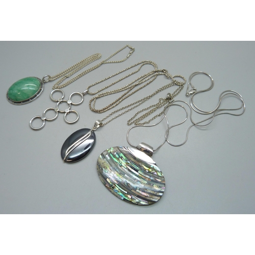 974 - Four silver and silver mounted pendants and chains, all test as silver