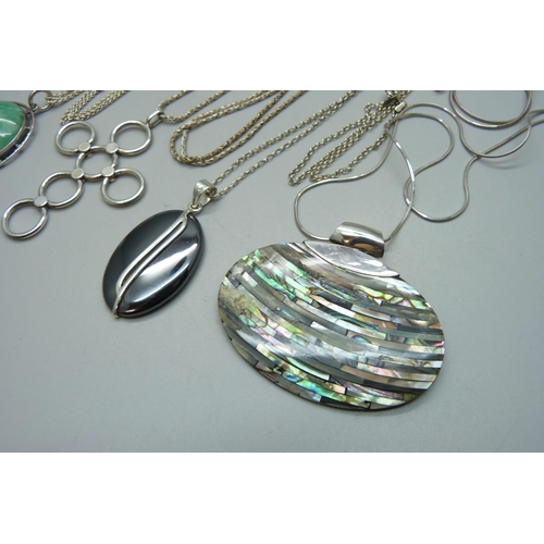 974 - Four silver and silver mounted pendants and chains, all test as silver