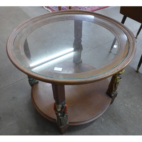 105 - A French oak and glass topped circular two tier coffee table