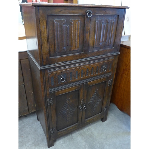 130 - A carved oak linenfold cocktail cabinet