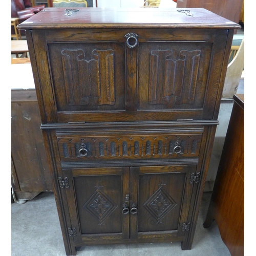 130 - A carved oak linenfold cocktail cabinet