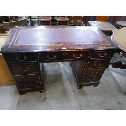 161 - A mahogany and red leather topped desk