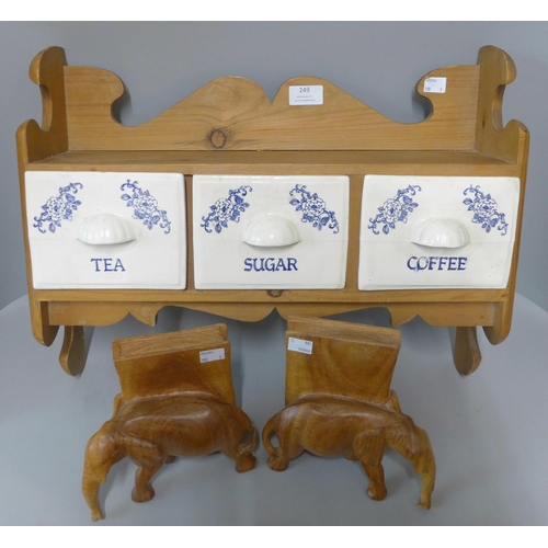 249 - A pine wall hanging tea, coffee and sugar rack and a pair of carved wooden elephant book ends