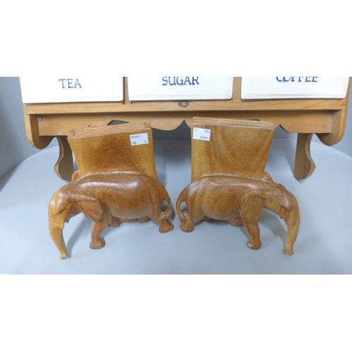 249 - A pine wall hanging tea, coffee and sugar rack and a pair of carved wooden elephant book ends