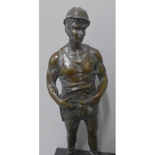 285 - A bronze figure of a miner, on black marble socle