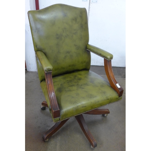 36 - A mahogany and green leather revolving desk chair