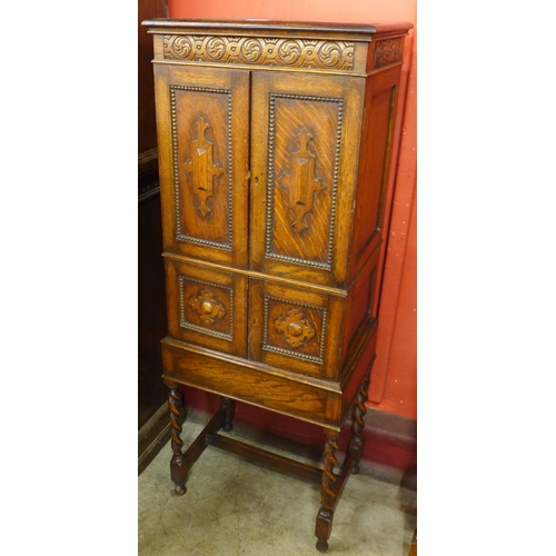 39 - A carved oak barleytwist four door cupboard