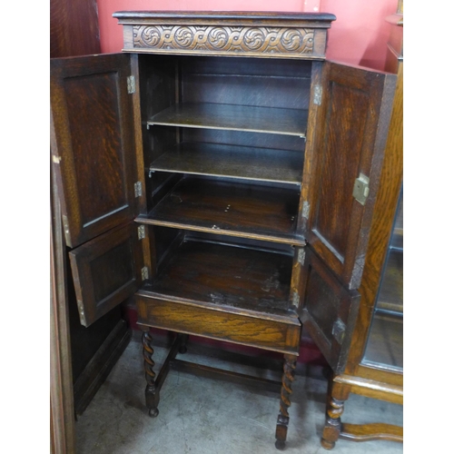 39 - A carved oak barleytwist four door cupboard