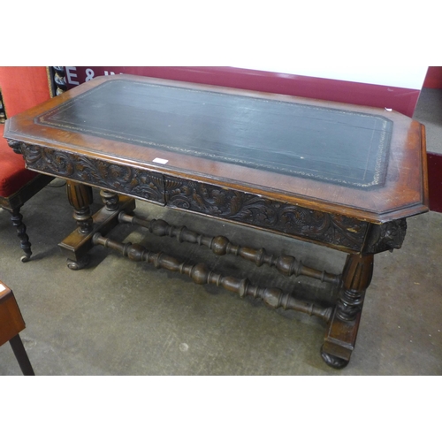 45 - A Victorian Jacobean Revival carved oak and leather topped two drawer writing table