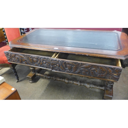 45 - A Victorian Jacobean Revival carved oak and leather topped two drawer writing table