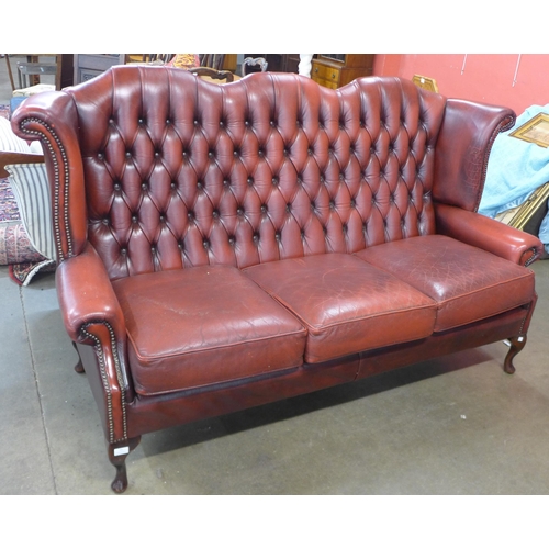 53 - A Chesterfield red leather wingback settee