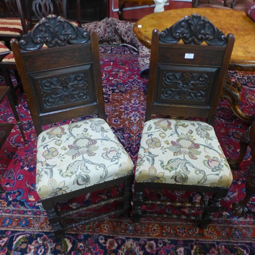 65 - A pair of early 20th Century carved oak hall chairs