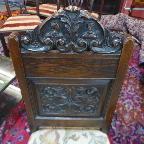 65 - A pair of early 20th Century carved oak hall chairs