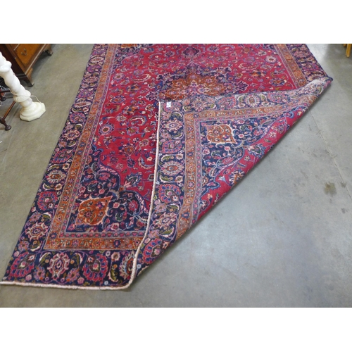 84 - An eastern red ground rug, 350 x 237cms