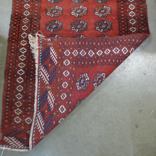 91 - An eastern red ground runner rug, 125 x 61cms