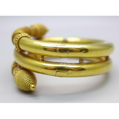 1049 - A Victorian snake style gilt metal bangle with hinge opening, inner dimensions 45mm x 58mm, 61g