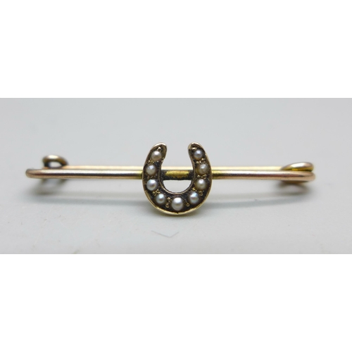 1053 - A yellow metal and seed pearl horseshoe bar brooch, tests as 9ct gold, 1.1g