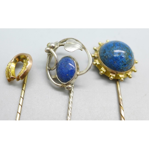 1082 - Three stick pins; one horseshoe marked gold, one Art Nouveau marked silver and one yellow metal set ... 