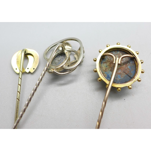 1082 - Three stick pins; one horseshoe marked gold, one Art Nouveau marked silver and one yellow metal set ... 