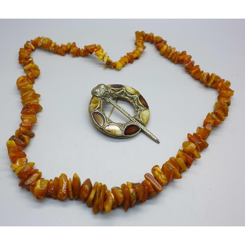 1100 - A Baltic amber necklace and a Scottish kilt pin style brooch