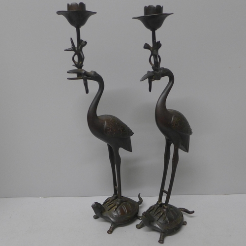 776 - A pair of bronze candlesticks, 20th Century, storks stood on turtles, one beak a/f, 31.5cm