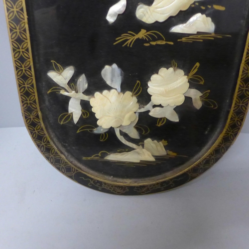 779 - A chinoiserie ebonised panel overlaid with mother of pearl, 91cm