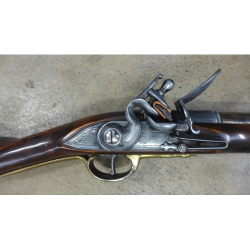 791 - A replica Brown Bess musket, a leather tricorn hat and powder horn