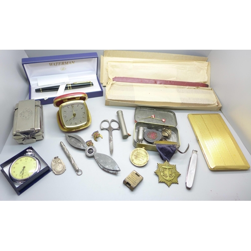 873 - A Waterman ink pen, a slab of Superfine Sealing Wax, travel clock, tin of medallions, plated cigaret... 